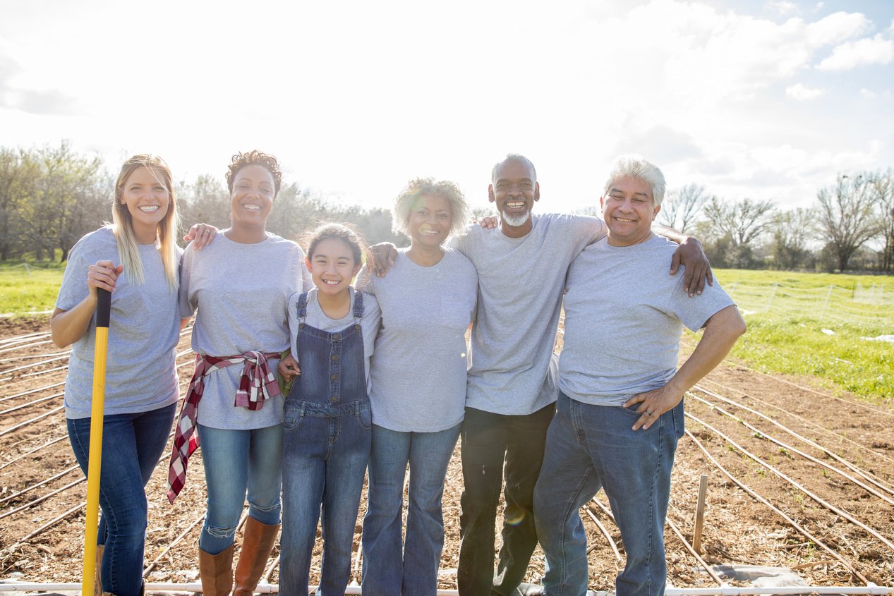 Diverse group of people plant community garden